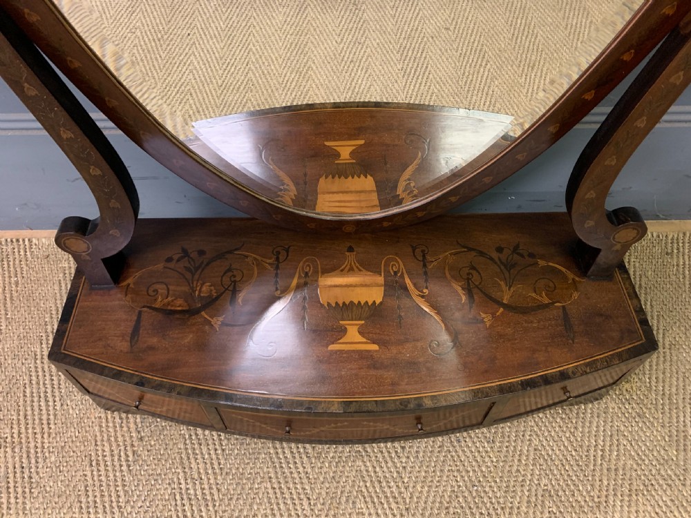 A Georgian mahogany toilet mirror featuring a shield-shaped swing frame, inlaid satinwood urn motifs, and a drawer base with curved fronting. View III