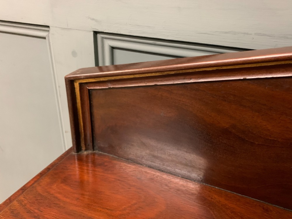 A dark mahogany Victorian hall table featuring spiral turned legs with gold accents, a scalloped apron, and an elevated gallery back with a central brass crest. View VII