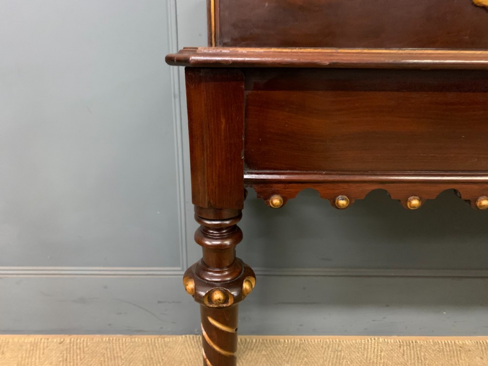 A dark mahogany Victorian hall table featuring spiral turned legs with gold accents, a scalloped apron, and an elevated gallery back with a central brass crest. View VIII