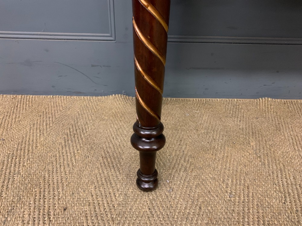 A dark mahogany Victorian hall table featuring spiral turned legs with gold accents, a scalloped apron, and an elevated gallery back with a central brass crest. View IX