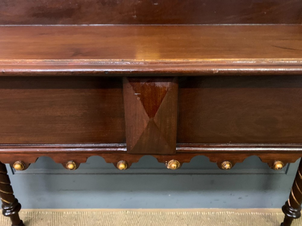 A dark mahogany Victorian hall table featuring spiral turned legs with gold accents, a scalloped apron, and an elevated gallery back with a central brass crest. View X