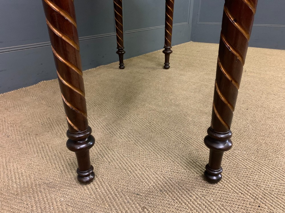 A dark mahogany Victorian hall table featuring spiral turned legs with gold accents, a scalloped apron, and an elevated gallery back with a central brass crest. View XIII