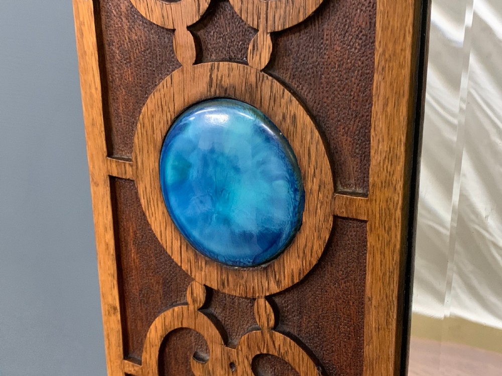An Arts and Crafts golden oak sideboard featuring a mirrored superstructure with carved fretwork and blue ceramic cabochons above two drawers and two cupboard doors. View XIII