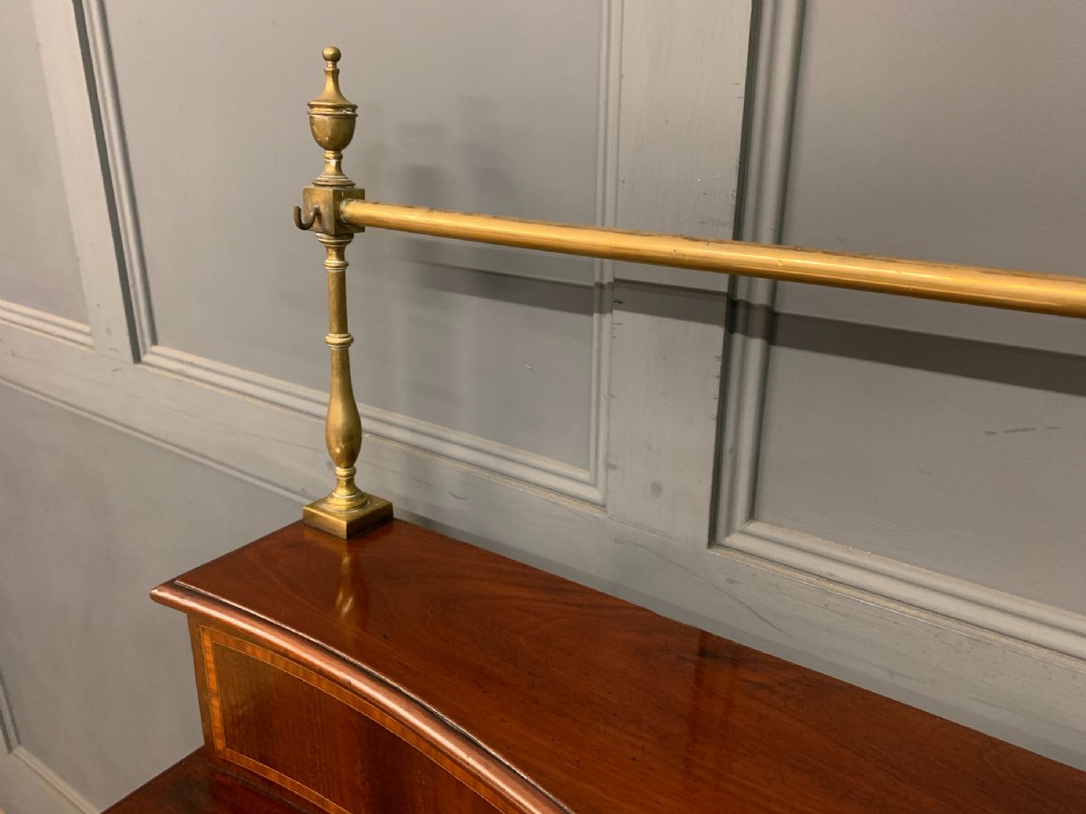 A George III mahogany serving table featuring a serpentine front, inlaid fluted detailing, square tapered legs, and a brass gallery rail. View XI