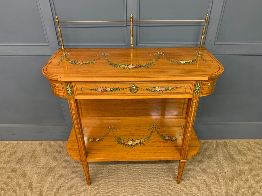 A painted satinwood side table featuring hand-painted floral swags, a single drawer, a lower shelf, tapered square legs, and a raised brass gallery rail. View III
