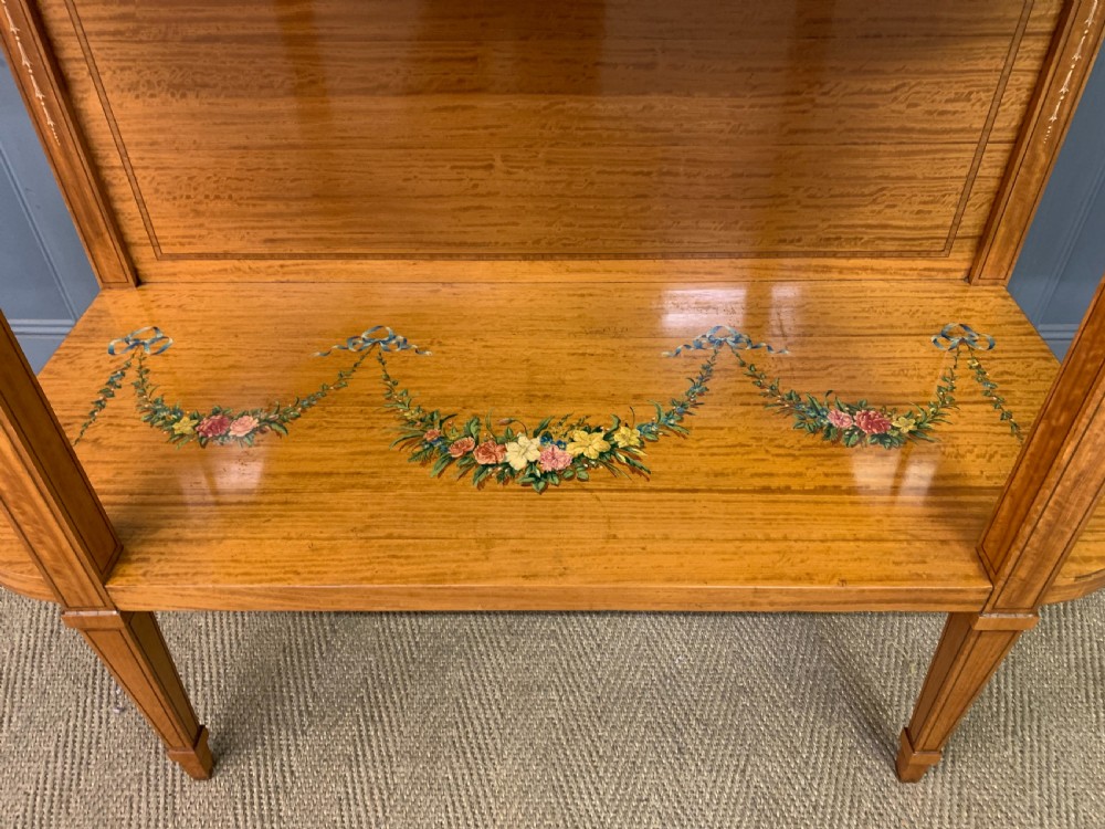 A painted satinwood side table featuring hand-painted floral swags, a single drawer, a lower shelf, tapered square legs, and a raised brass gallery rail. View XI