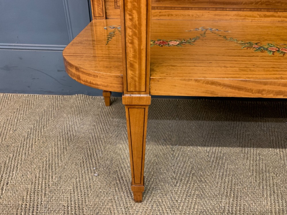 A painted satinwood side table featuring hand-painted floral swags, a single drawer, a lower shelf, tapered square legs, and a raised brass gallery rail. View XII