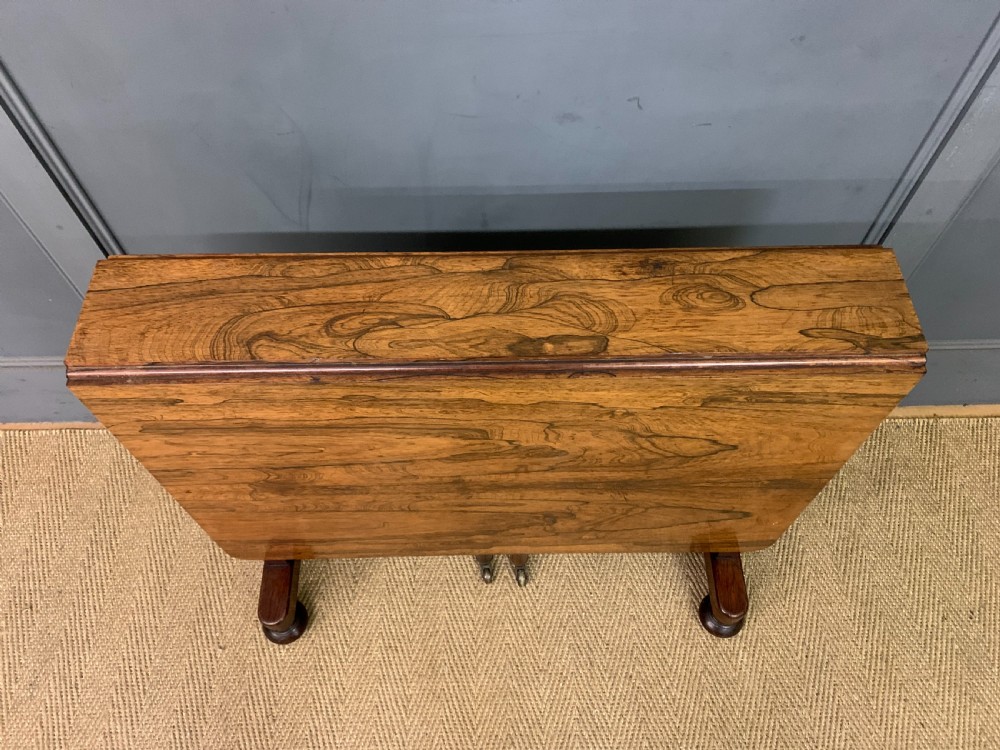 A William IV rosewood Sutherland table featuring folded drop-leaf sides, turned supports, and platform feet with castors. View IV