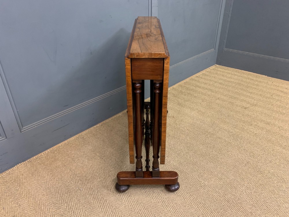 A William IV rosewood Sutherland table featuring folded drop-leaf sides, turned supports, and platform feet with castors. View V