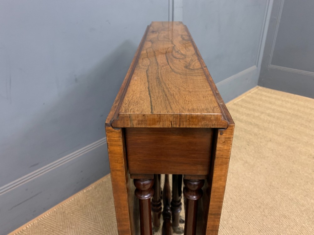 A William IV rosewood Sutherland table featuring folded drop-leaf sides, turned supports, and platform feet with castors. View VII