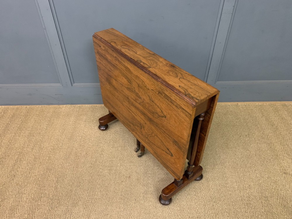 A William IV rosewood Sutherland table featuring folded drop-leaf sides, turned supports, and platform feet with castors. View VIII