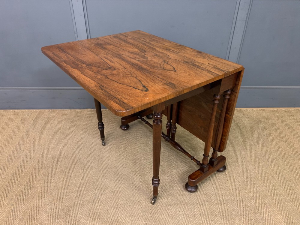 A William IV rosewood Sutherland table featuring folded drop-leaf sides, turned supports, and platform feet with castors. View IX
