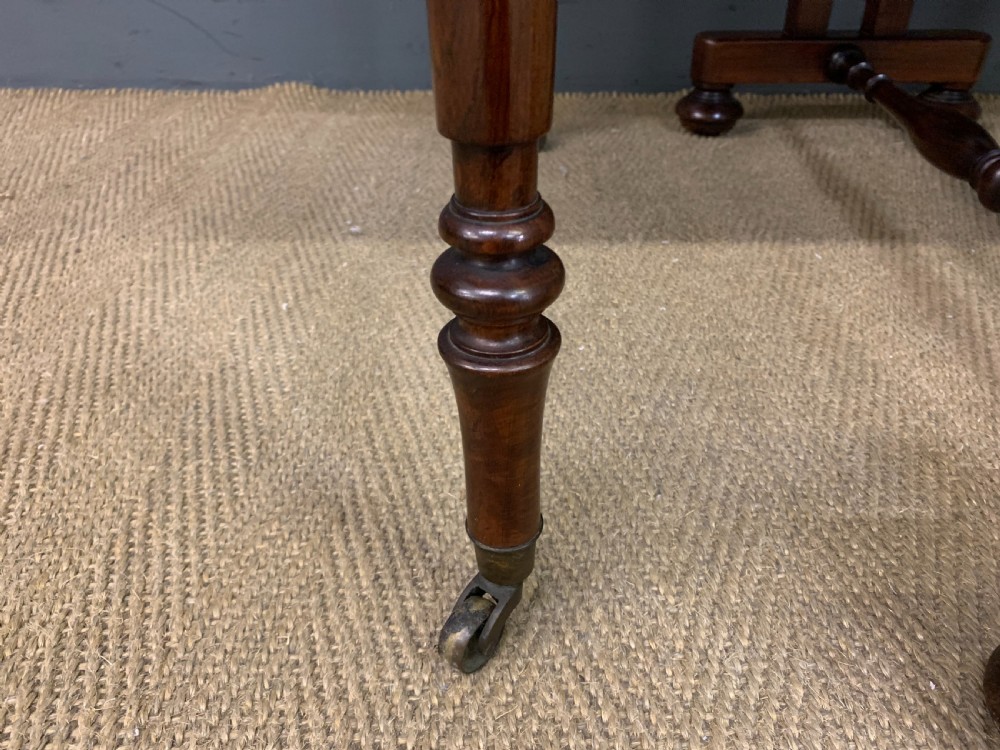 A William IV rosewood Sutherland table featuring folded drop-leaf sides, turned supports, and platform feet with castors. View XI