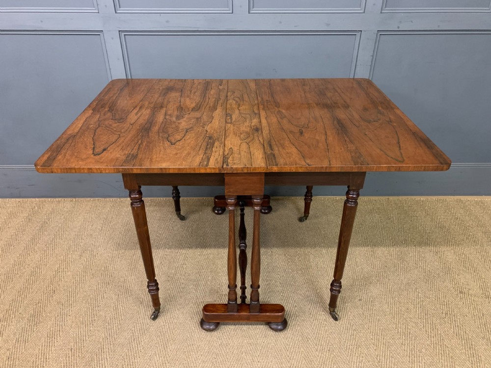 A William IV rosewood Sutherland table featuring folded drop-leaf sides, turned supports, and platform feet with castors. View XII