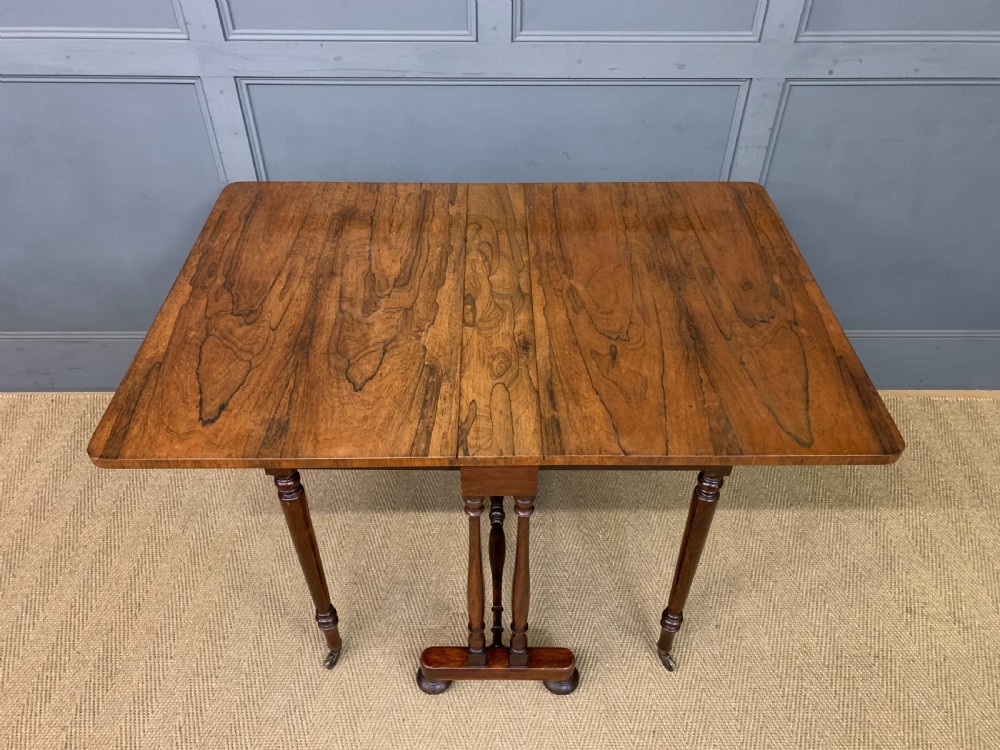 A William IV rosewood Sutherland table featuring folded drop-leaf sides, turned supports, and platform feet with castors. View XIII
