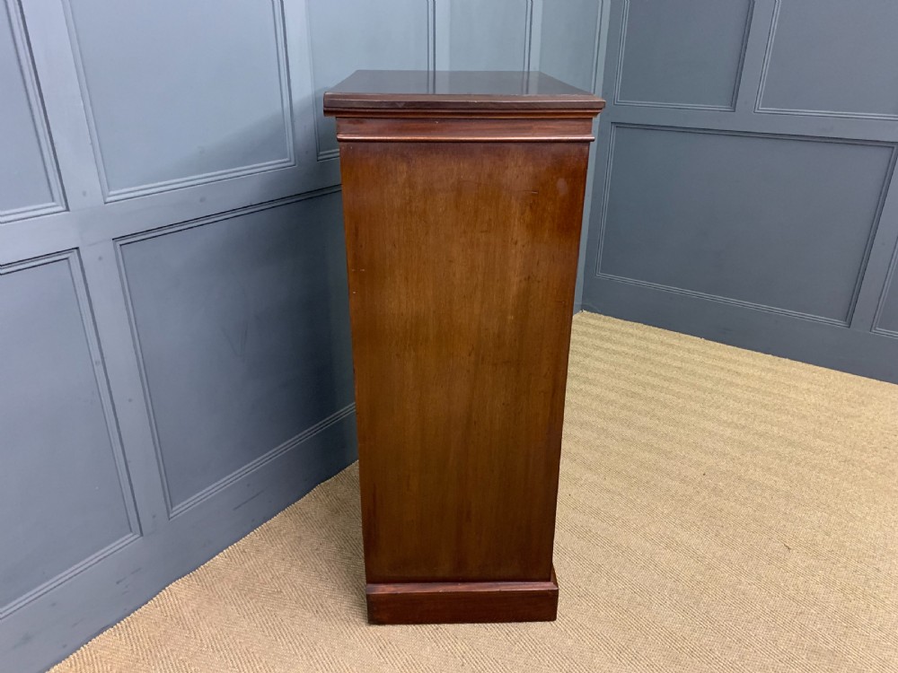 A tall Edwardian mahogany pillar chest featuring seven inlaid drawers with brass drop handles on a plinth base. View XI