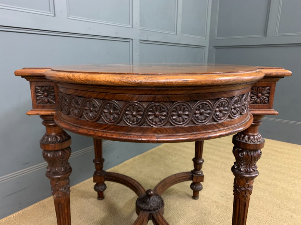 An Anglo-Indian rosewood games table featuring an inlaid square chessboard top, drop leaves, a carved frieze, and turned legs connected by a curved stretcher. View XIII