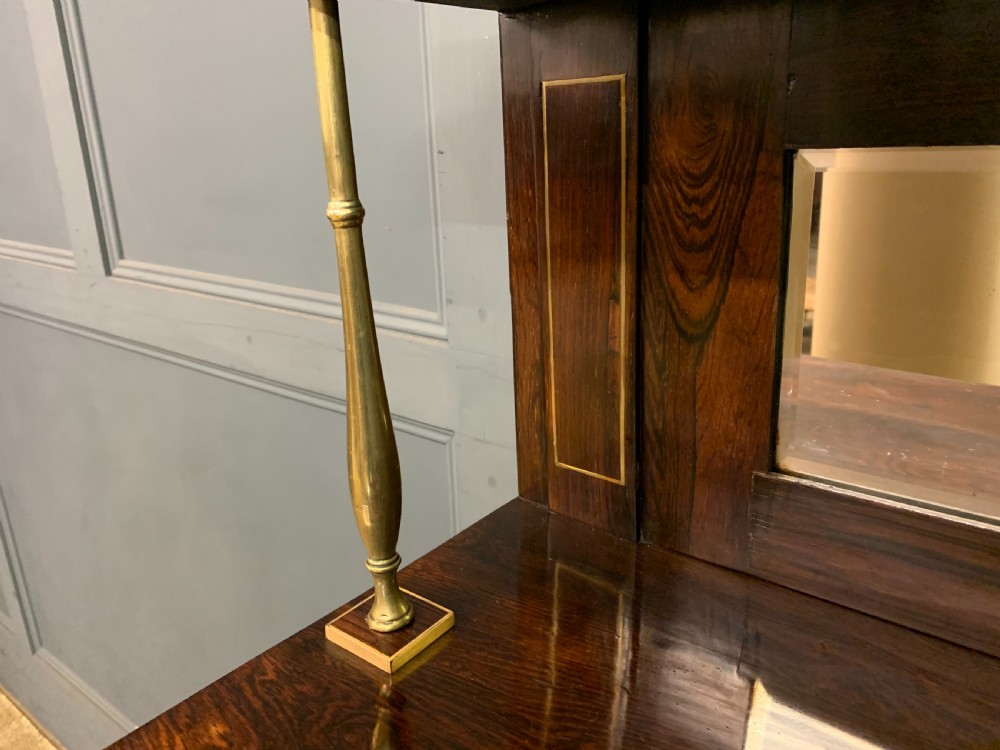 An antique Regency rosewood chiffonier featuring ornate brass inlay, a top mirror back with a brass gallery rail, and twin doors with brass wire mesh. View XIV