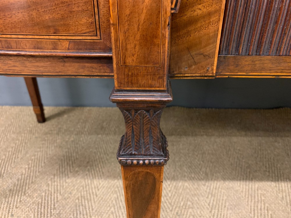 An antique George III inlaid mahogany sideboard with flame wood veneers, tambour doors, and brass ring drawer handles. View VII