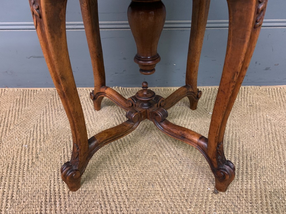 A French carved walnut adjustable piano stool with cabriole legs, carved floral apron, X-shaped stretcher, and a round light yellow upholstered seat. View III