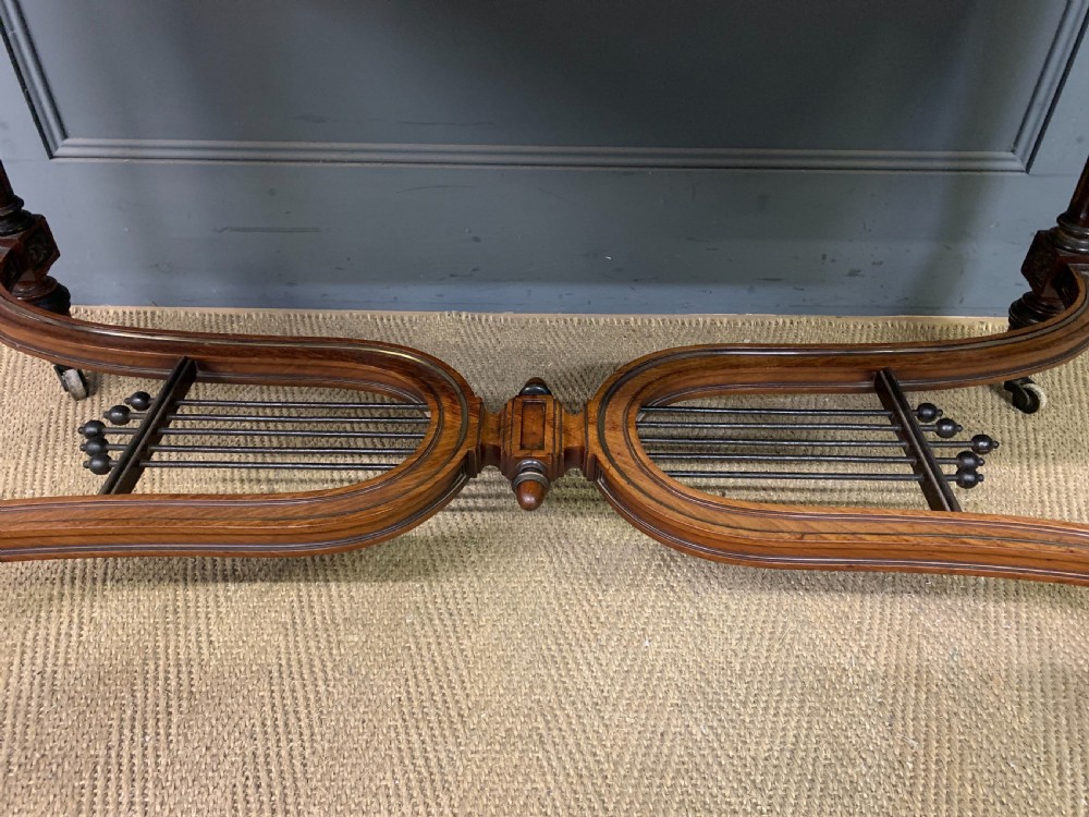 A rectangular French mahogany library table featuring a polished top, frieze drawer with carved detail, brass trim, turned fluted legs, and a lower carved stretcher on brass castors. View VIII