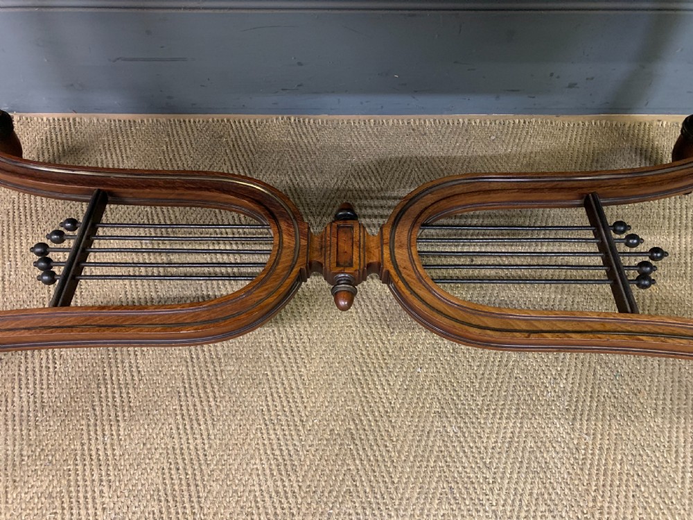 A rectangular French mahogany library table featuring a polished top, frieze drawer with carved detail, brass trim, turned fluted legs, and a lower carved stretcher on brass castors. View IX