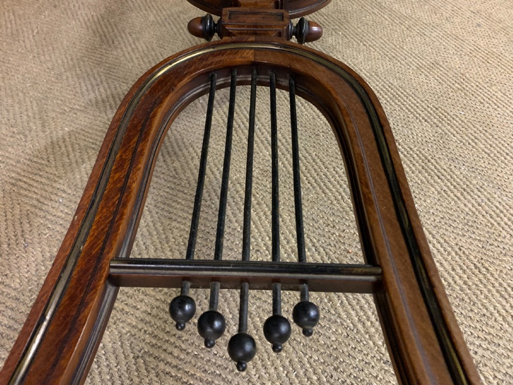 A rectangular French mahogany library table featuring a polished top, frieze drawer with carved detail, brass trim, turned fluted legs, and a lower carved stretcher on brass castors. View XVII