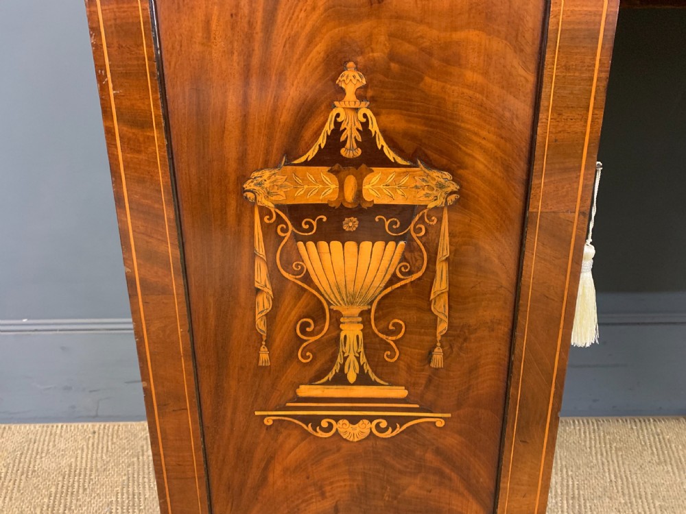 A George III inlaid mahogany pedestal sideboard featuring twin cupboard pedestals decorated with urn marquetry and a shaped backboard. View VI