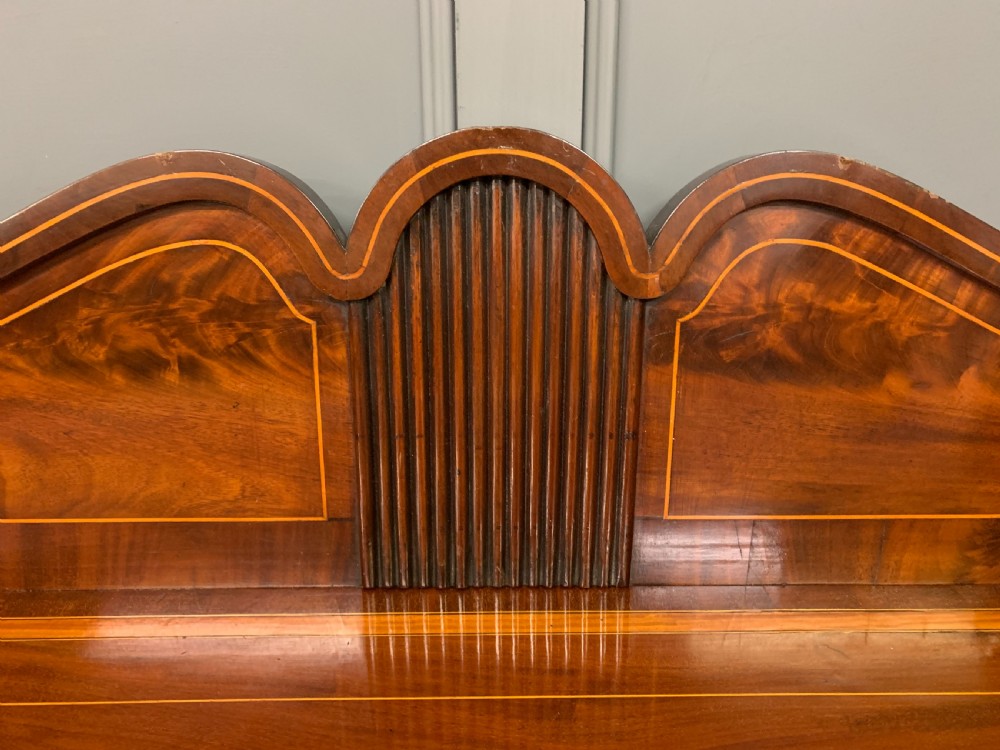 A George III inlaid mahogany pedestal sideboard featuring twin cupboard pedestals decorated with urn marquetry and a shaped backboard. View XII