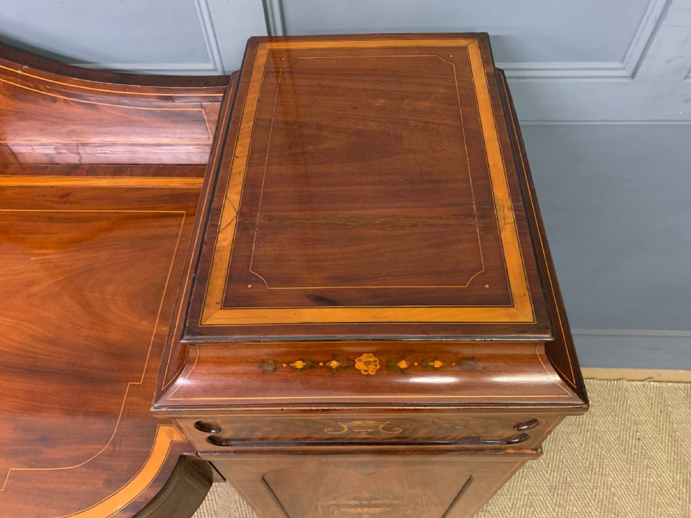 A George III inlaid mahogany pedestal sideboard featuring twin cupboard pedestals decorated with urn marquetry and a shaped backboard. View XIII