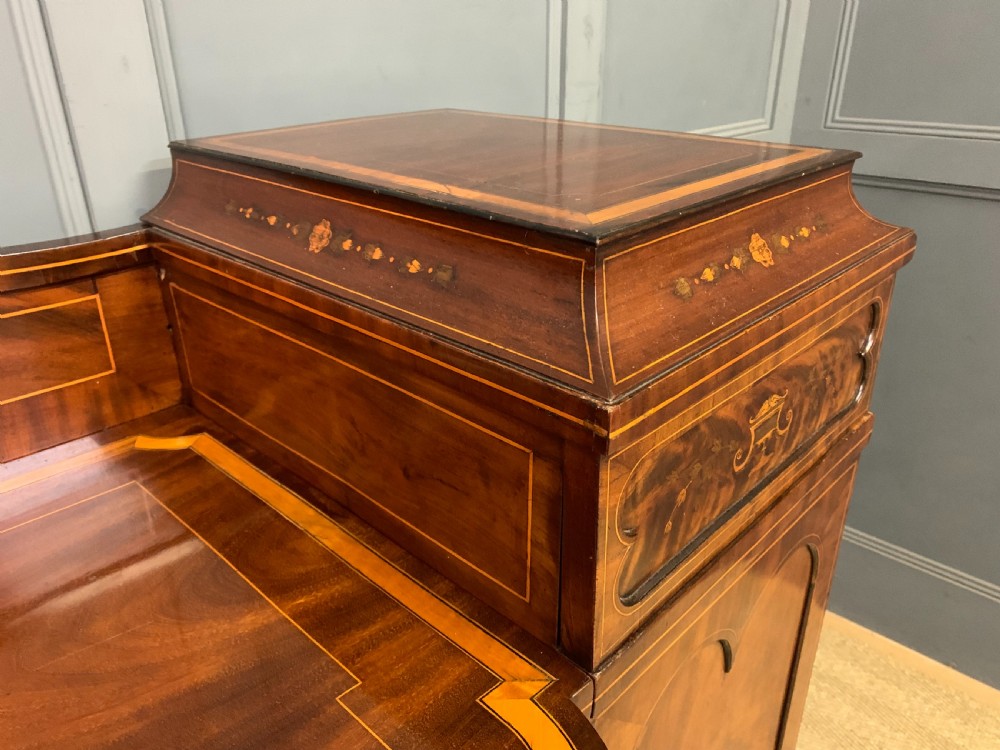 A George III inlaid mahogany pedestal sideboard featuring twin cupboard pedestals decorated with urn marquetry and a shaped backboard. View XV