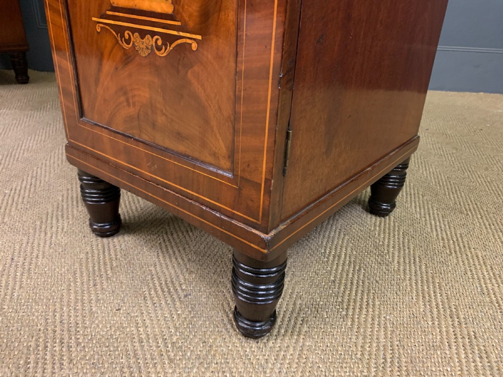 A George III inlaid mahogany pedestal sideboard featuring twin cupboard pedestals decorated with urn marquetry and a shaped backboard. View XXIV