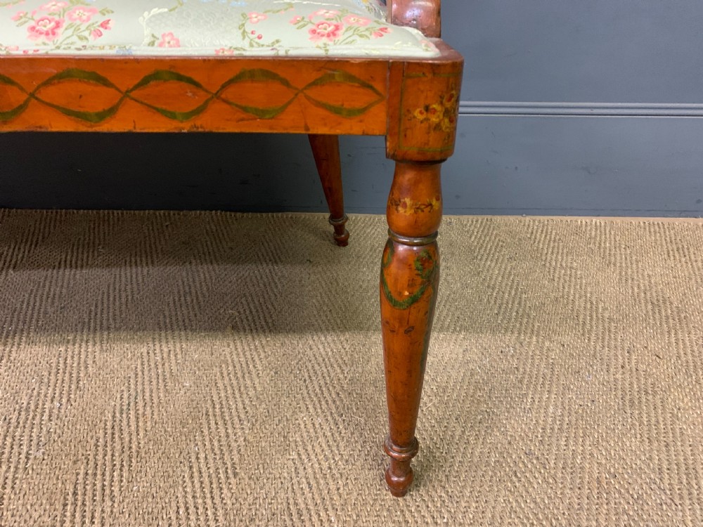 A painted satinwood three-seat settee with central portrait medallions and a light green floral upholstered cushion. View II