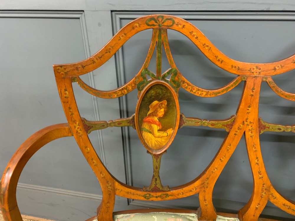 A painted satinwood three-seat settee with central portrait medallions and a light green floral upholstered cushion. View IV