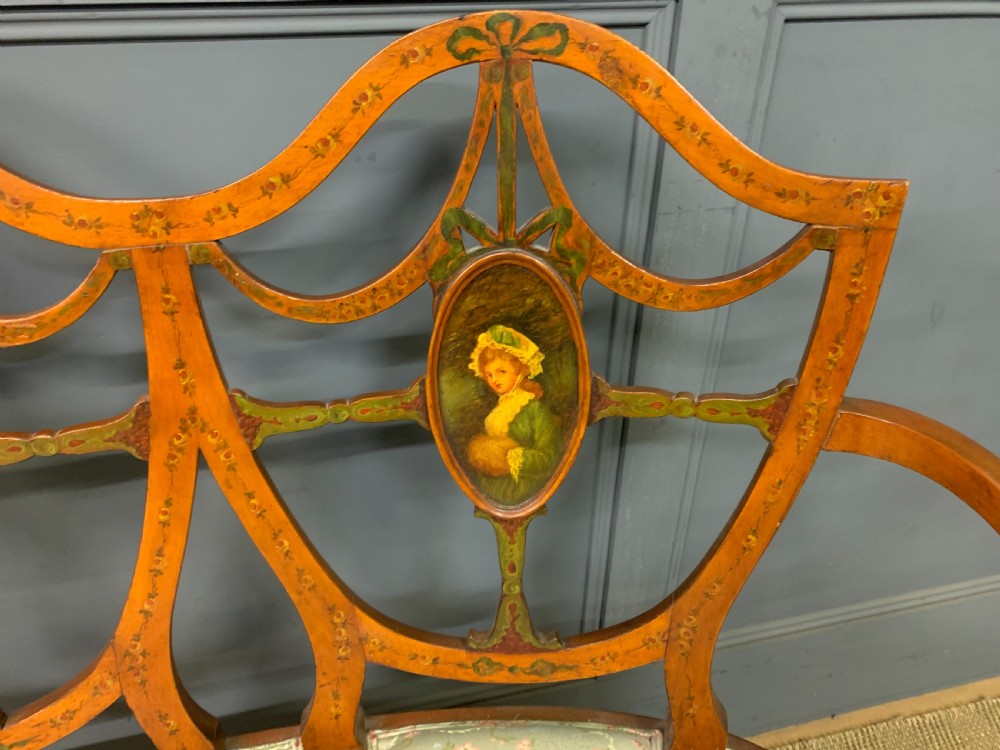 A painted satinwood three-seat settee with central portrait medallions and a light green floral upholstered cushion. View VI