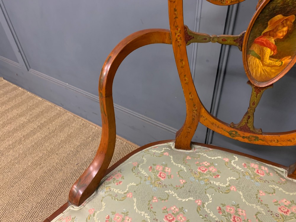 A painted satinwood three-seat settee with central portrait medallions and a light green floral upholstered cushion. View VII