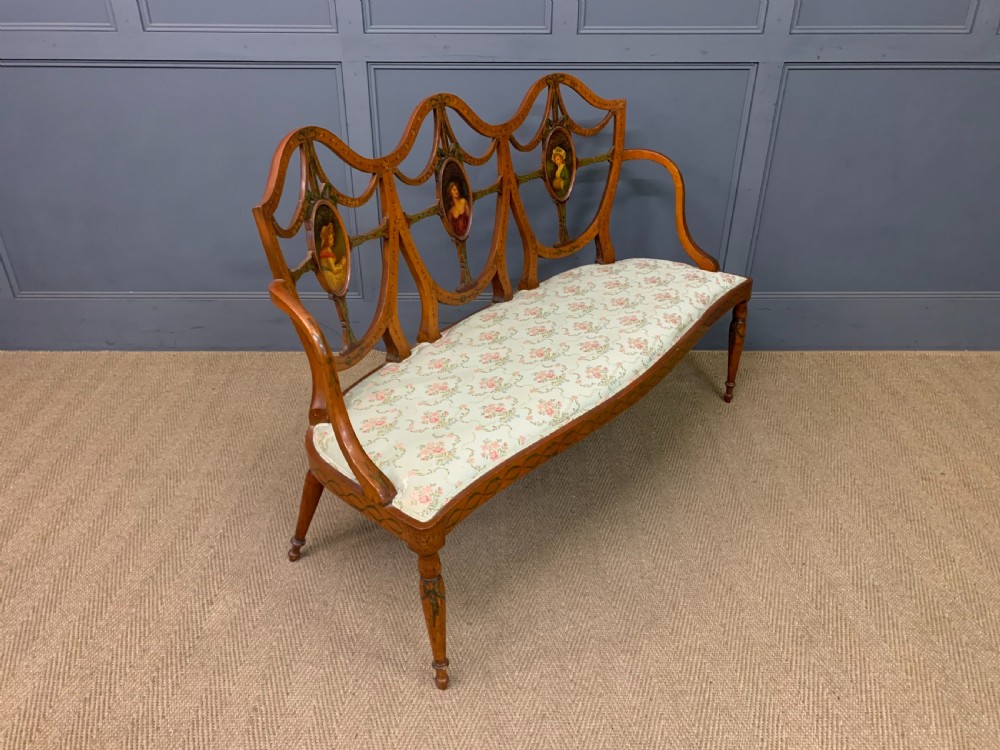 A painted satinwood three-seat settee with central portrait medallions and a light green floral upholstered cushion. View IX