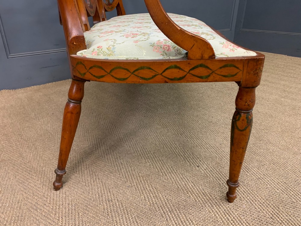A painted satinwood three-seat settee with central portrait medallions and a light green floral upholstered cushion. View XI