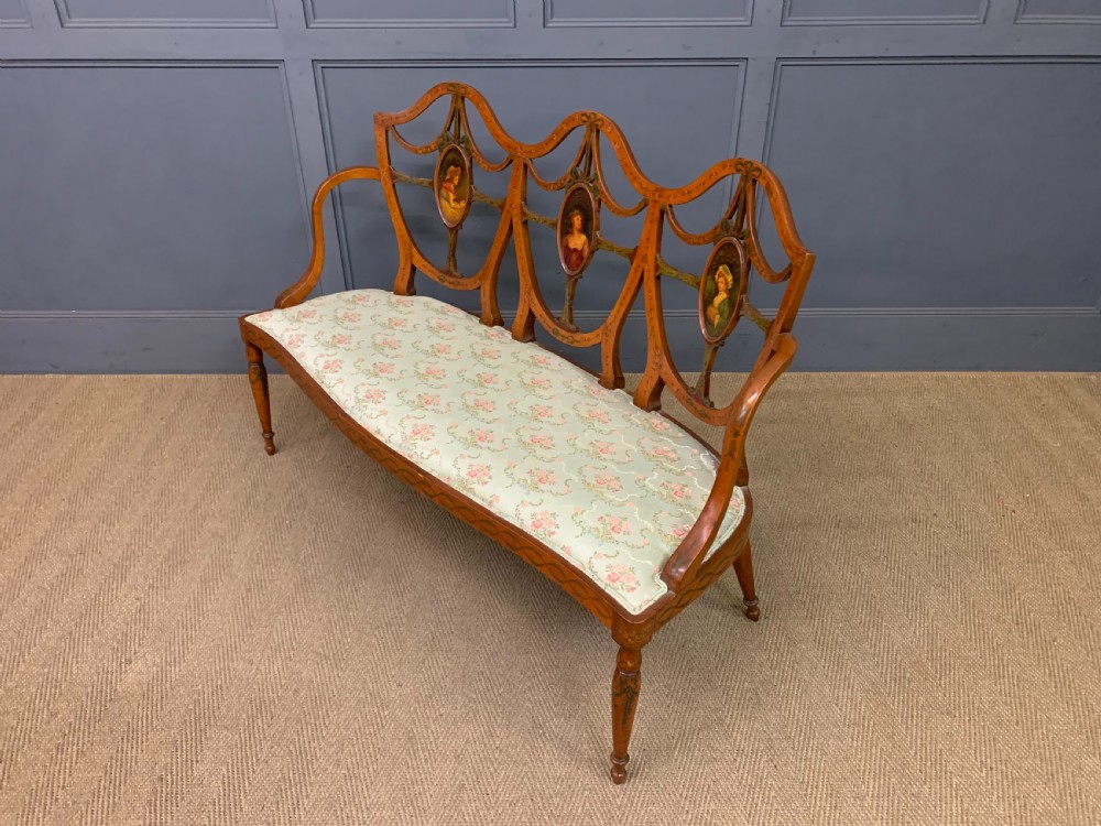 A painted satinwood three-seat settee with central portrait medallions and a light green floral upholstered cushion. View XIII