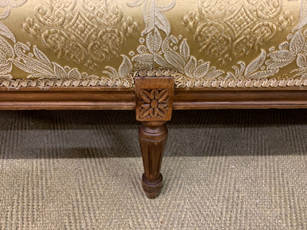 A three-piece French walnut salon suite featuring a sofa and two matching armchairs upholstered in gold patterned damask with deep buttoned backrests and fluted carved legs. View VI