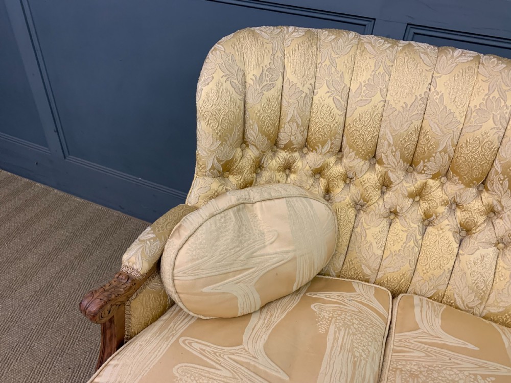 A three-piece French walnut salon suite featuring a sofa and two matching armchairs upholstered in gold patterned damask with deep buttoned backrests and fluted carved legs. View VII