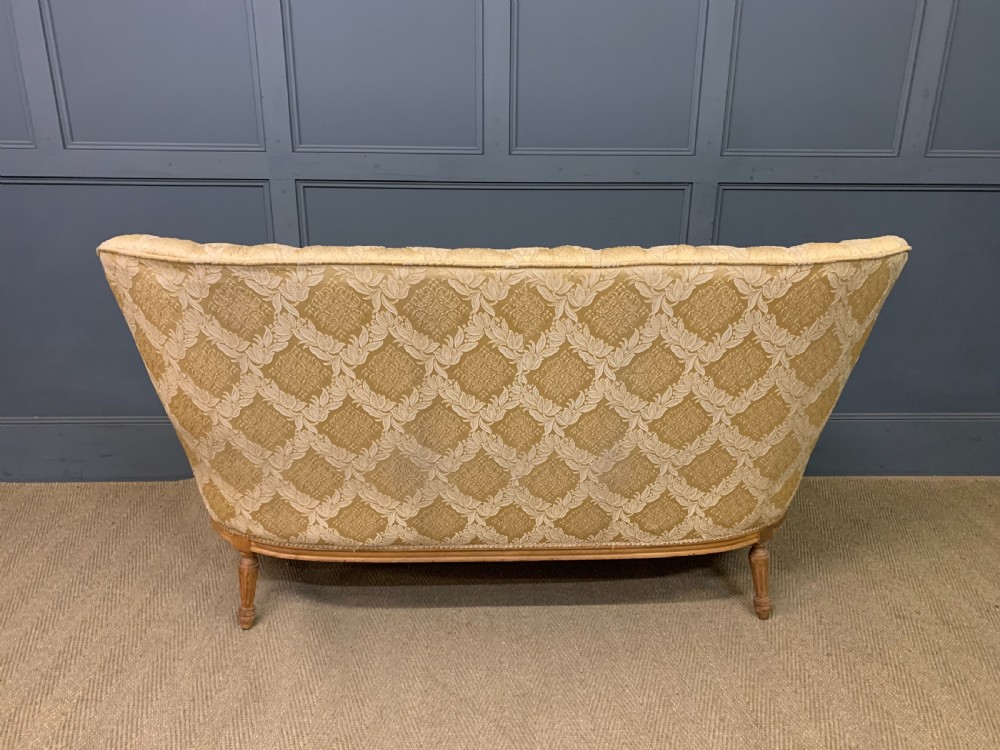 A three-piece French walnut salon suite featuring a sofa and two matching armchairs upholstered in gold patterned damask with deep buttoned backrests and fluted carved legs. View XII