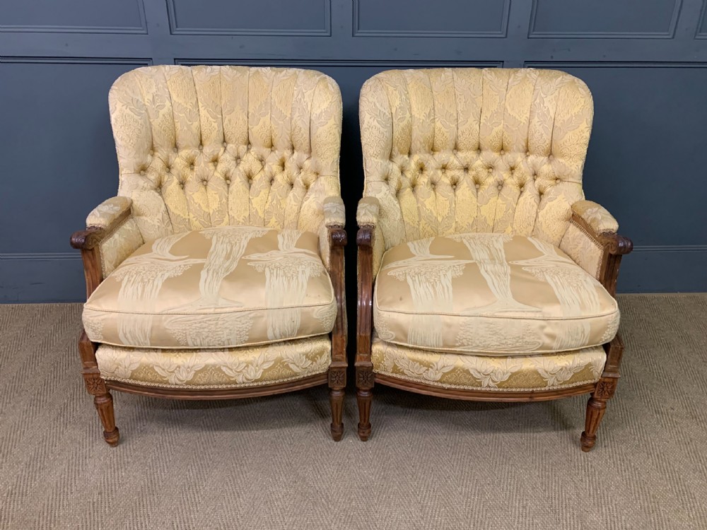 A three-piece French walnut salon suite featuring a sofa and two matching armchairs upholstered in gold patterned damask with deep buttoned backrests and fluted carved legs. View XIII