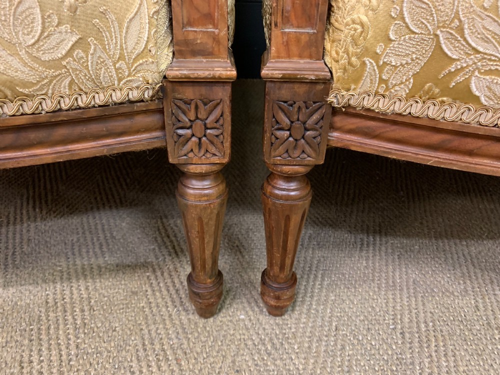 A three-piece French walnut salon suite featuring a sofa and two matching armchairs upholstered in gold patterned damask with deep buttoned backrests and fluted carved legs. View XIV