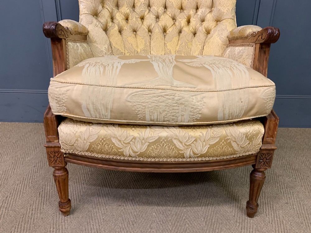 A three-piece French walnut salon suite featuring a sofa and two matching armchairs upholstered in gold patterned damask with deep buttoned backrests and fluted carved legs. View XX