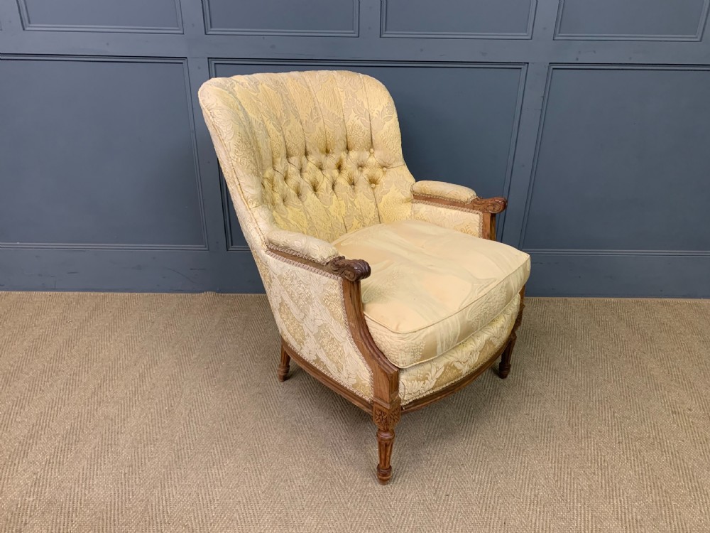 A three-piece French walnut salon suite featuring a sofa and two matching armchairs upholstered in gold patterned damask with deep buttoned backrests and fluted carved legs. View XXII