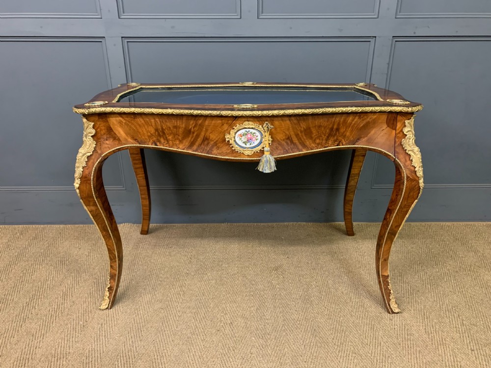 A 19th-century French Louis XV style bijouterie table with a glazed display top, curved cabriole legs, gilt bronze mounts, porcelain plaques, and a blue velvet interior. View III