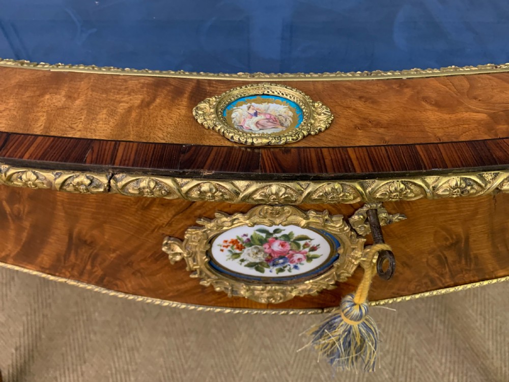 A 19th-century French Louis XV style bijouterie table with a glazed display top, curved cabriole legs, gilt bronze mounts, porcelain plaques, and a blue velvet interior. View VII