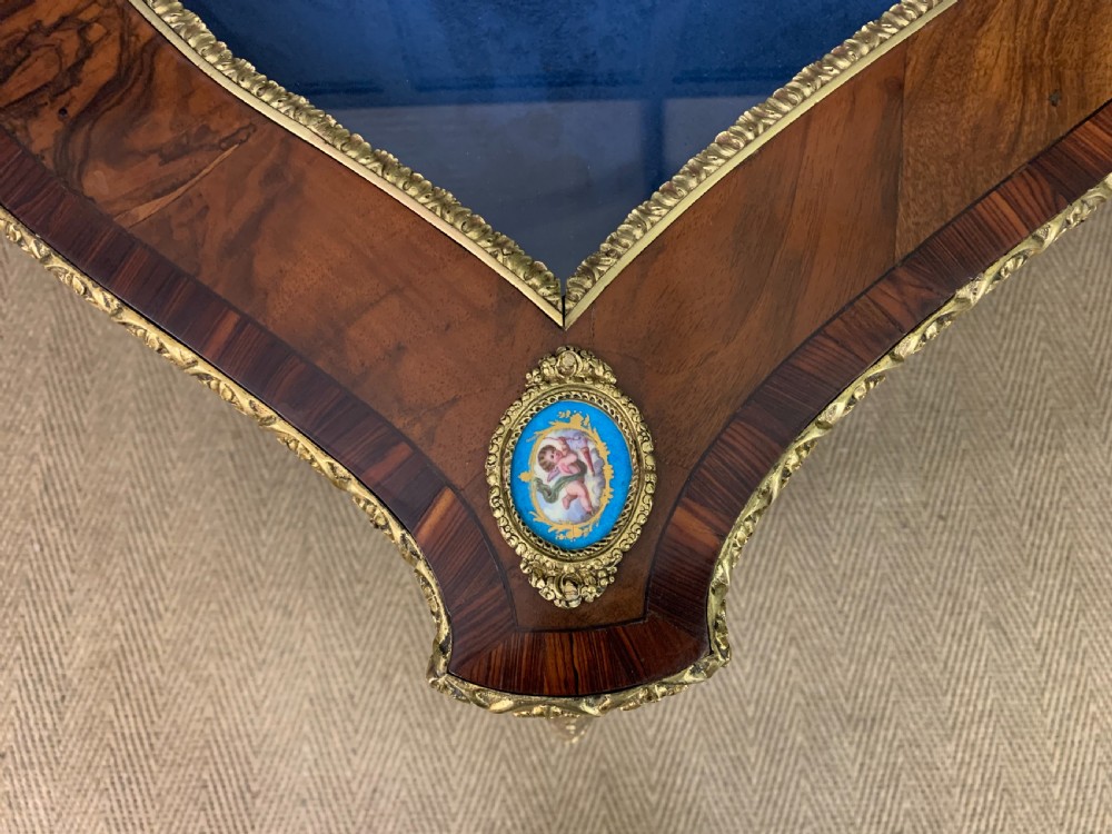 A 19th-century French Louis XV style bijouterie table with a glazed display top, curved cabriole legs, gilt bronze mounts, porcelain plaques, and a blue velvet interior. View XII