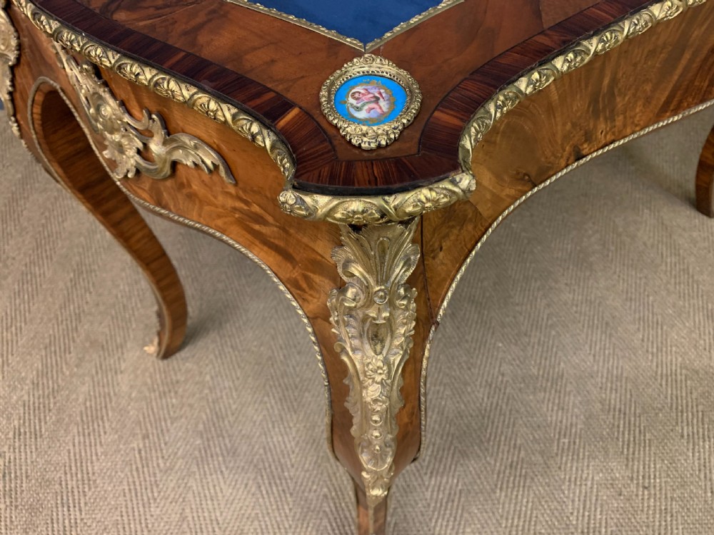 A 19th-century French Louis XV style bijouterie table with a glazed display top, curved cabriole legs, gilt bronze mounts, porcelain plaques, and a blue velvet interior. View XIII